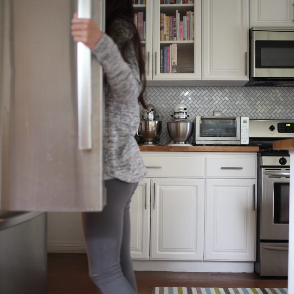 Woman looking inside refrigerator